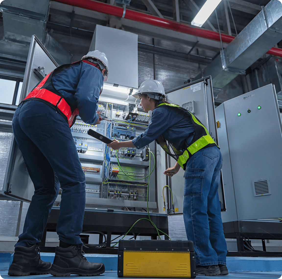 Workers examining control cabinet